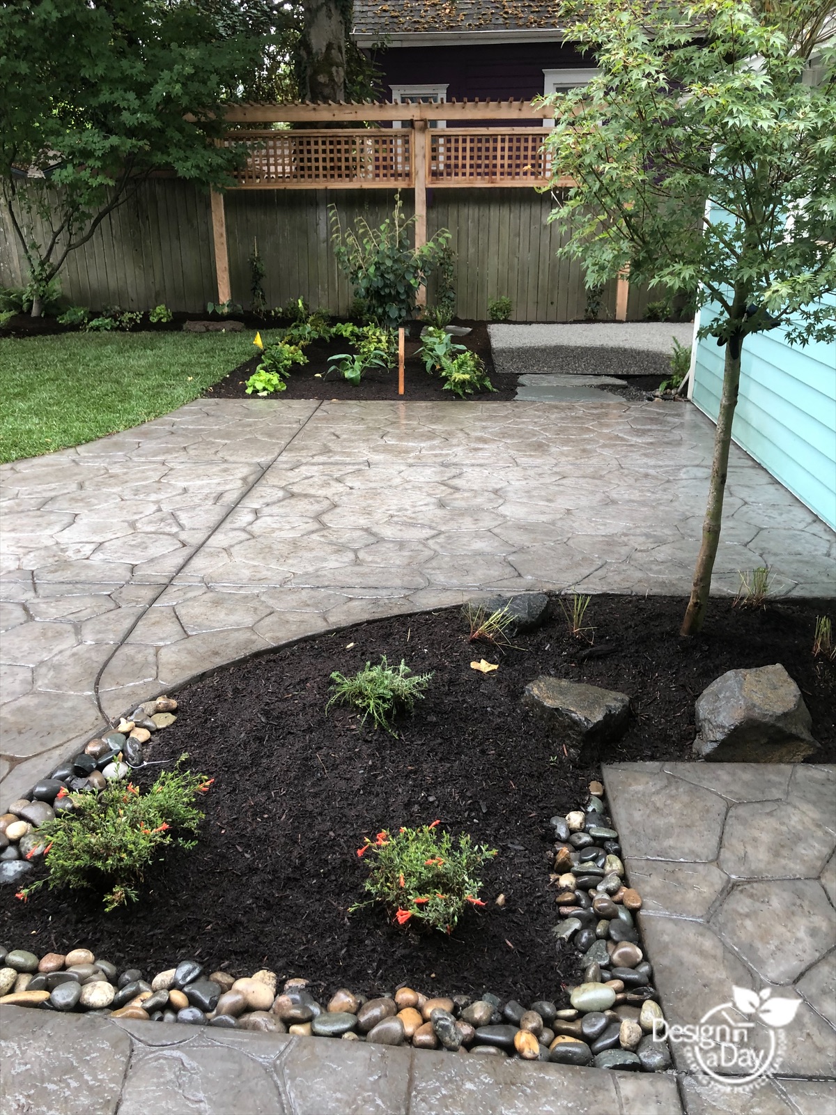 A wooden trellis, Japanese Maple and multiple planting beds complete this private backyard for the family in Portland, Oregon..