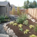 New plantings at Masterson garden receive blanket of mulch.
