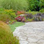 Dyed Stamped Concrete Patio and Plantings by Landscape Design in a Day